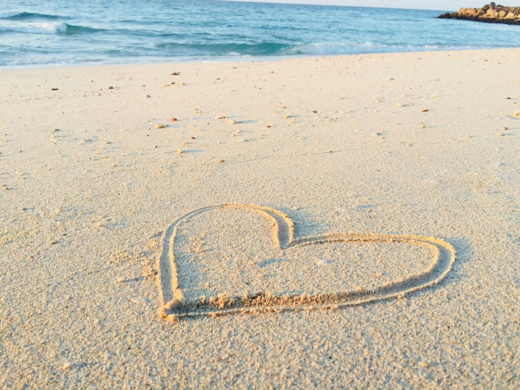 a heart drawn in the sand of a beach