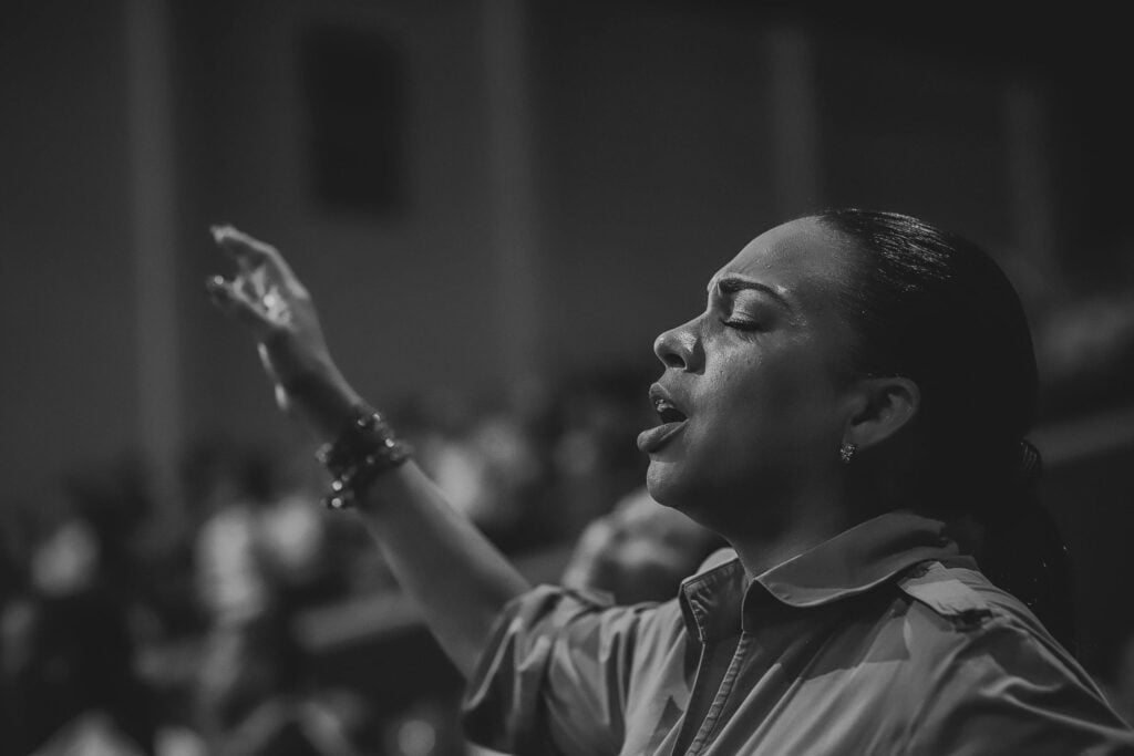 black and white photo of woman singing with eyes closed