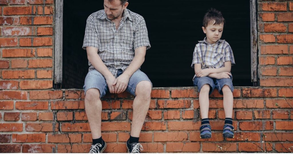 father and son sitting at a window