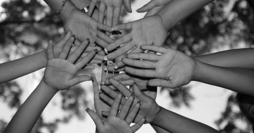 Black and white photo of outstretched hands